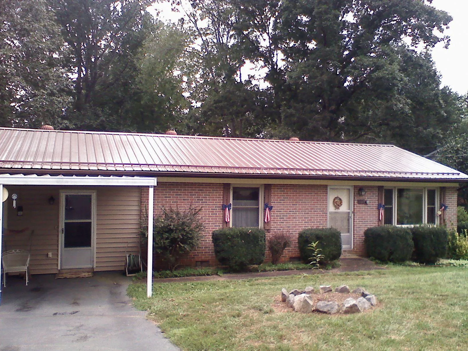Bronze metal roof and carport on a brick ranch home — Roof Repair work by our crew in Lunenburg